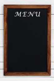 Image of Black chalkboard with word Menu on white wooden background. Mockup for design