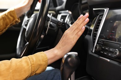 Photo of Woman checking air conditioner in her car, closeup