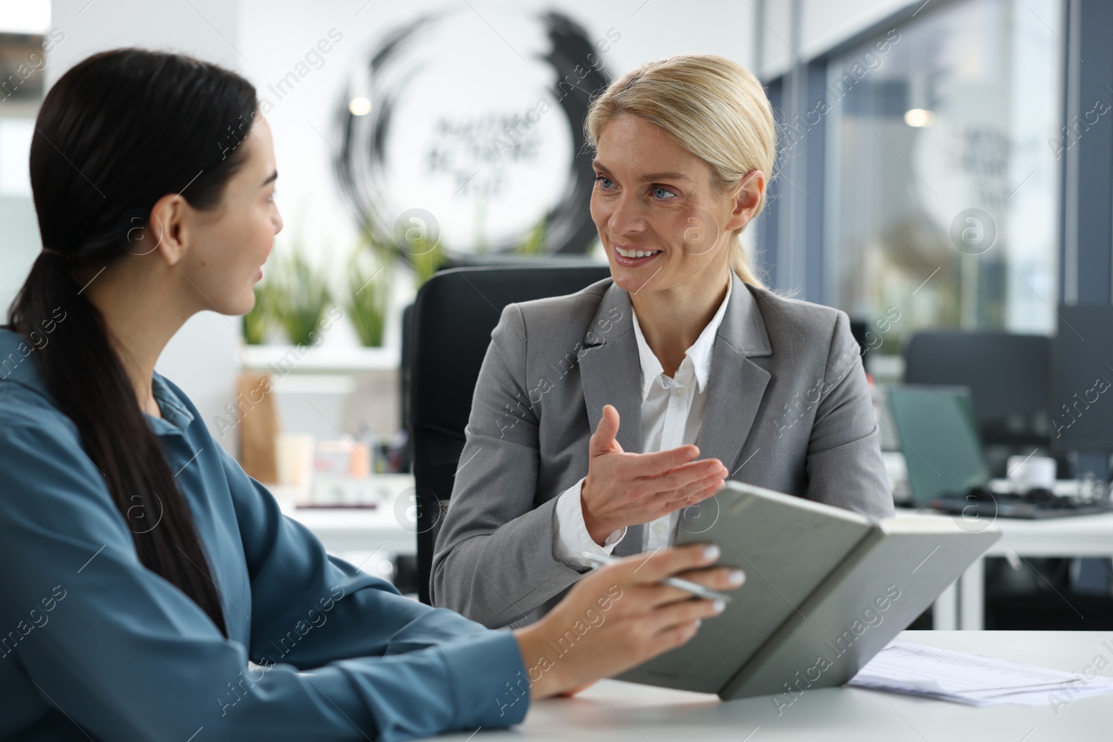 Photo of Lawyers with notebook working together at table in office