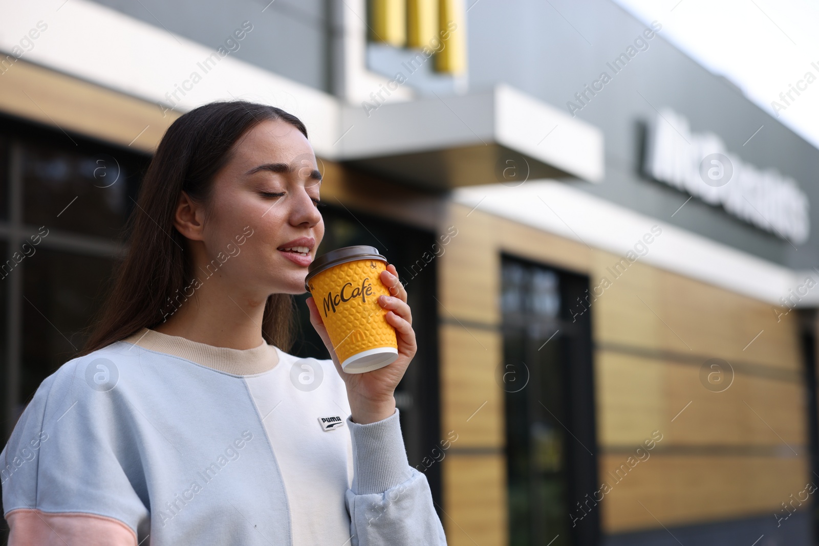 Photo of Lviv, Ukraine - September 26, 2023: Woman with hot McDonald's drink outdoors, space for text