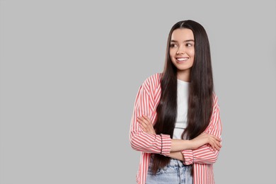 Portrait of happy teenage girl on light grey background. Space for text