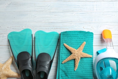 Flat lay composition with beach accessories on white wooden background, space for text