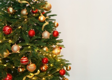 Photo of Beautiful Christmas tree with fairy lights and festive decor on white background