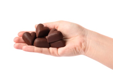 Woman holding heart shaped chocolate candies on white background, closeup
