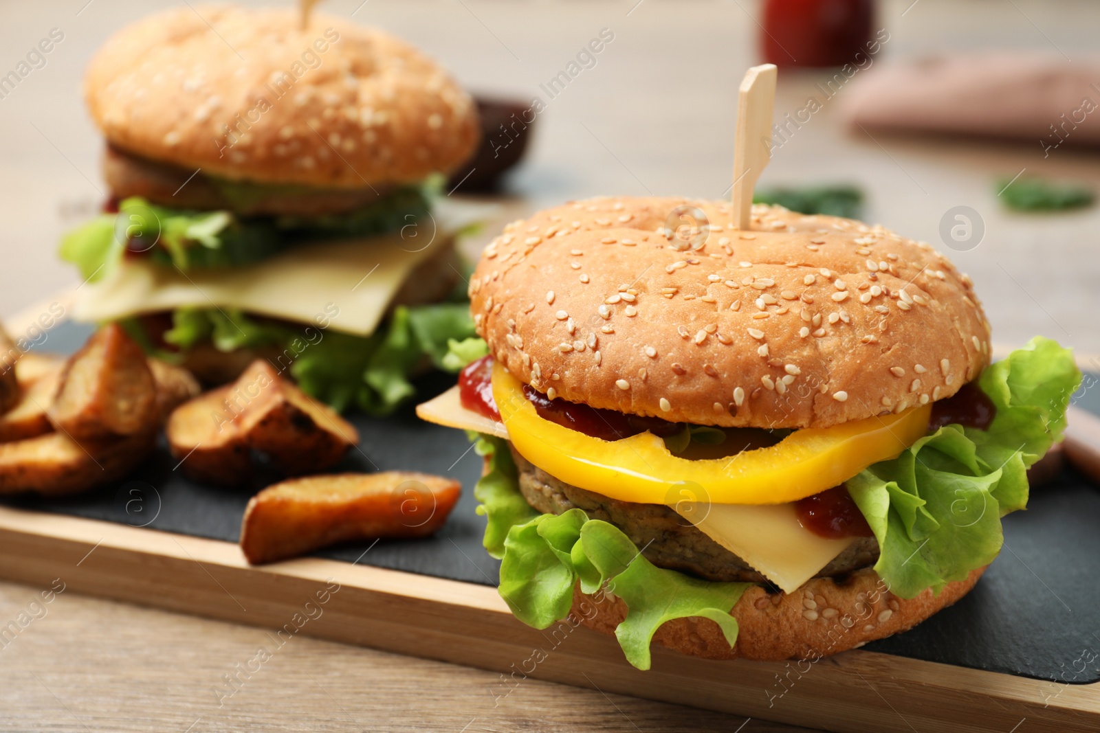 Photo of Board with delicious hamburger on table. Space for text