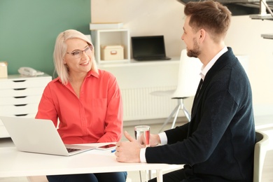 Photo of Mature woman consulting with man in office