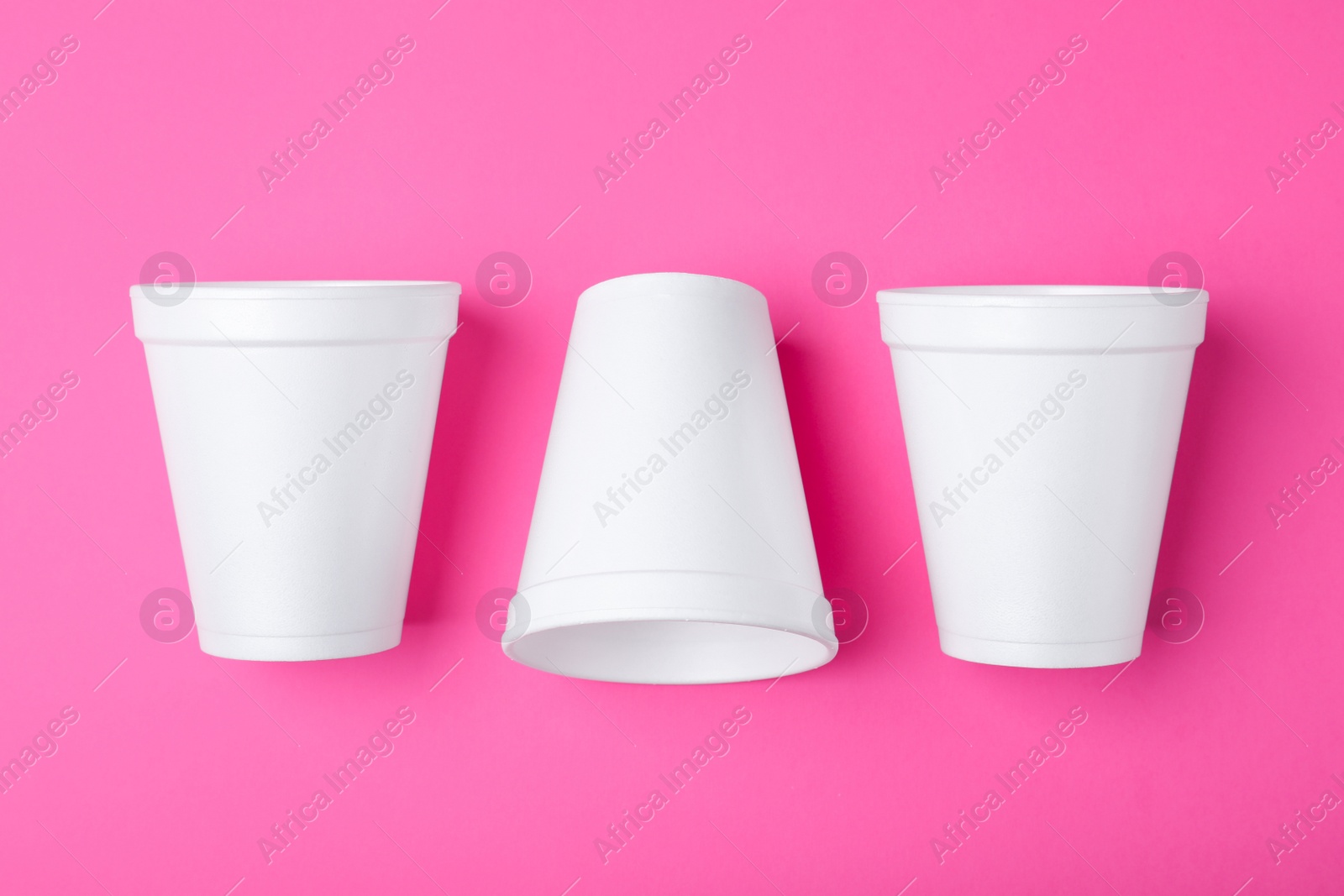 Photo of White styrofoam cups on pink background, flat lay