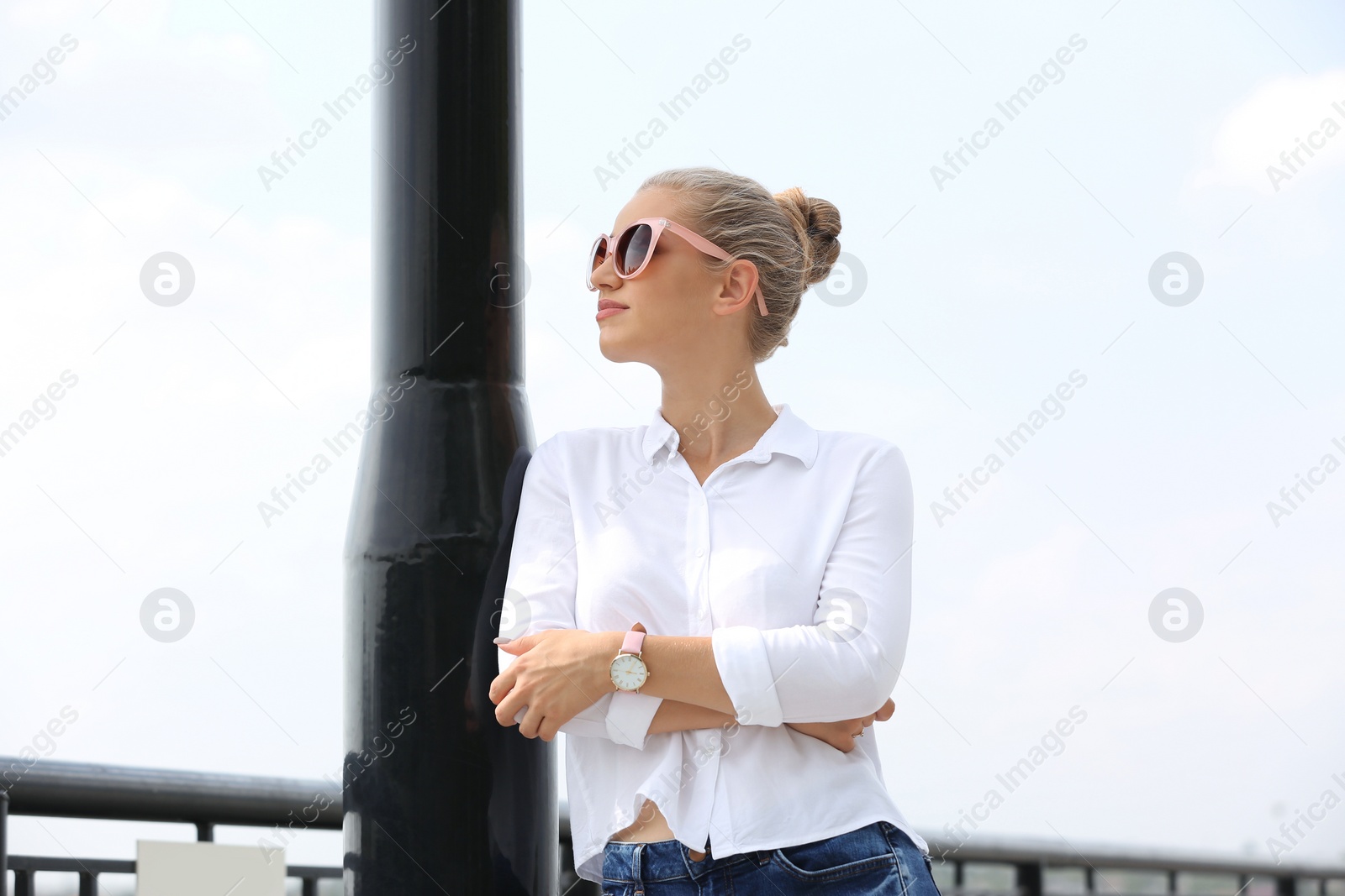 Photo of Beautiful young woman with sunglasses standing at pier. Joy in moment