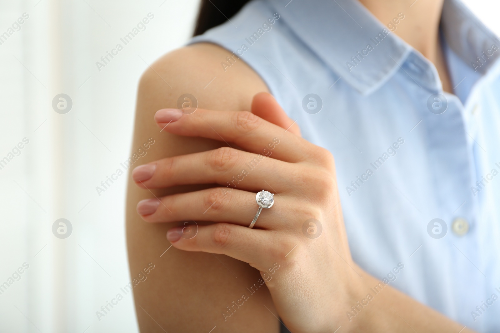 Photo of Young woman wearing beautiful engagement ring, closeup