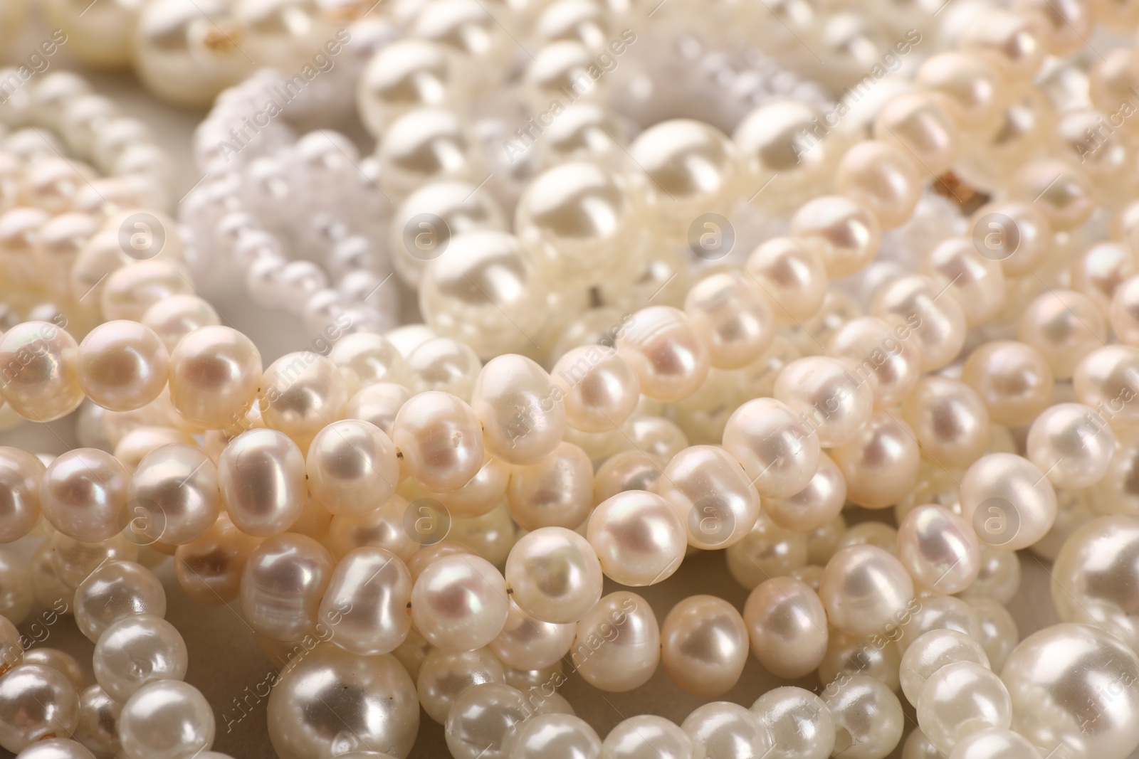 Photo of Elegant pearl necklaces as background, closeup view