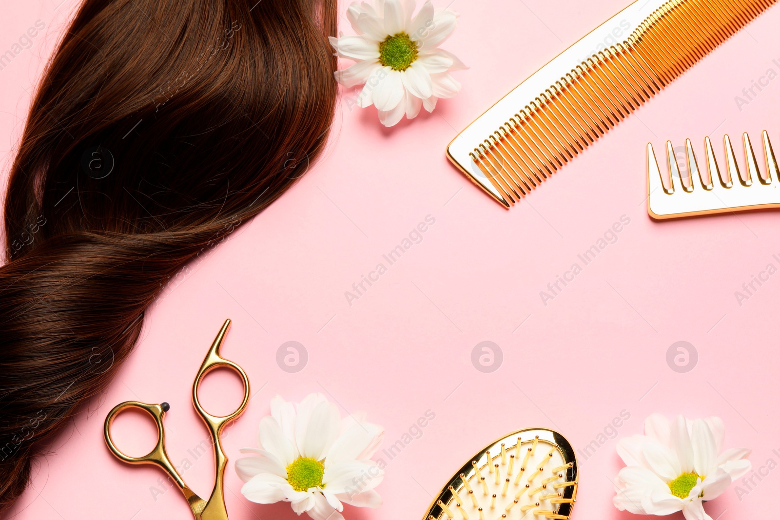 Photo of Flat lay composition with different hairdresser tools and flowers on pink background, space for text