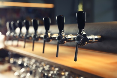 Photo of Row of shiny beer taps in pub