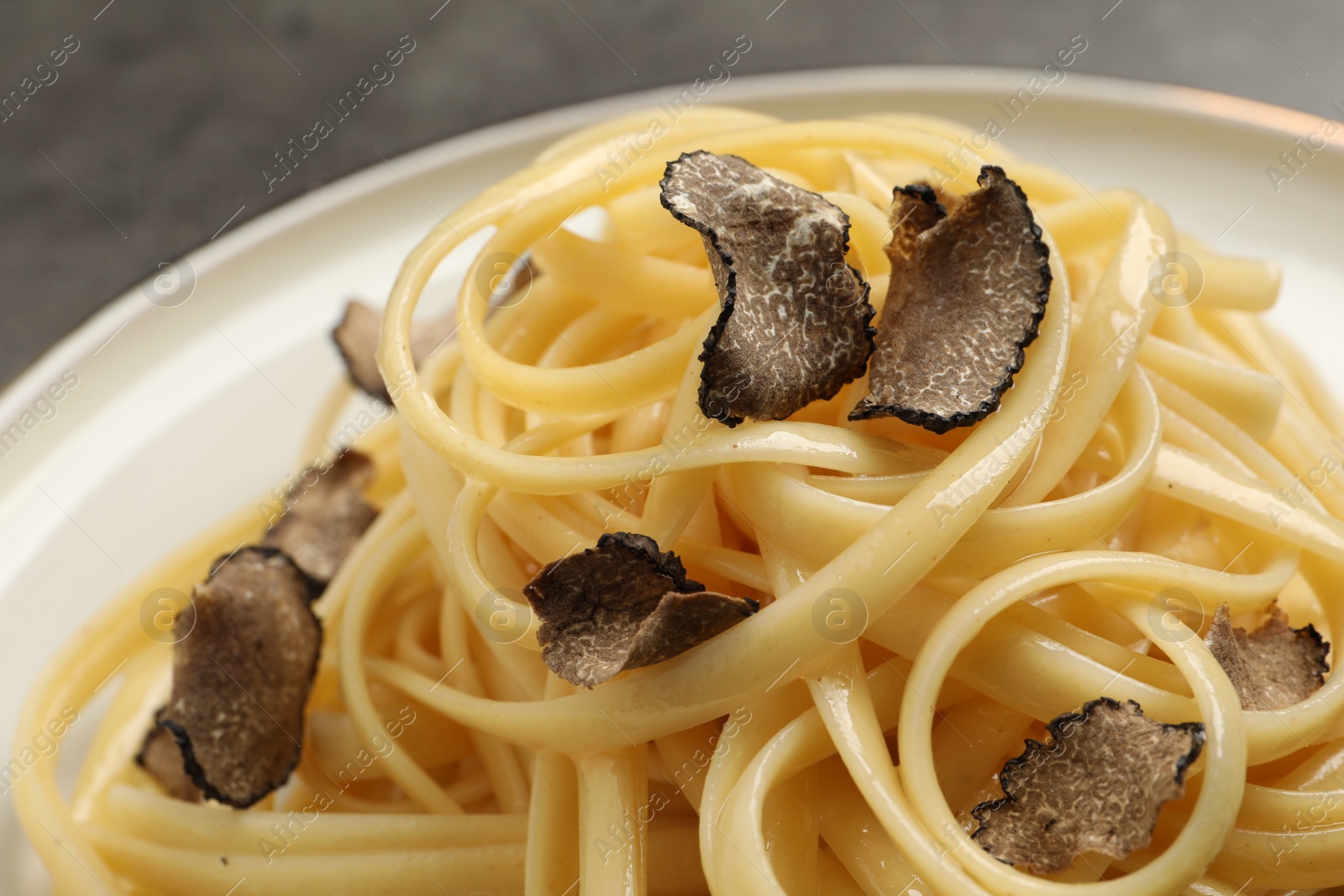Photo of Tasty fettuccine with truffle on plate, closeup