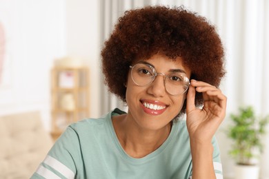 Photo of Portrait of happy young woman in eyeglasses indoors
