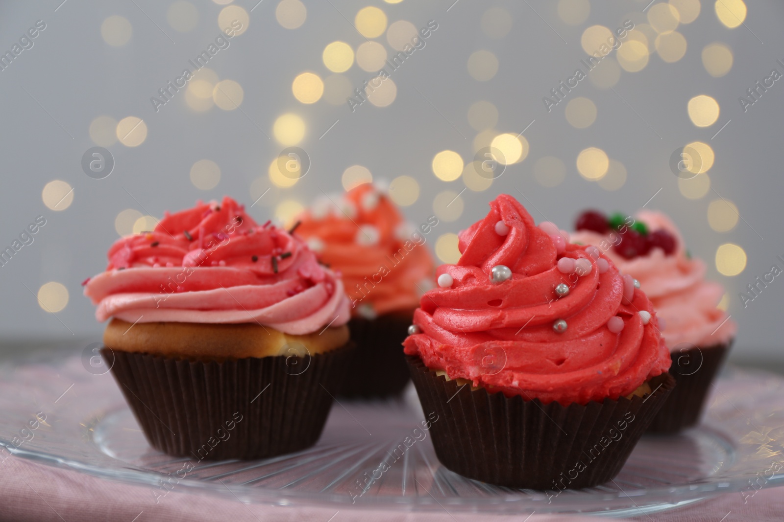 Photo of Delicious cupcakes with pink cream on table, closeup