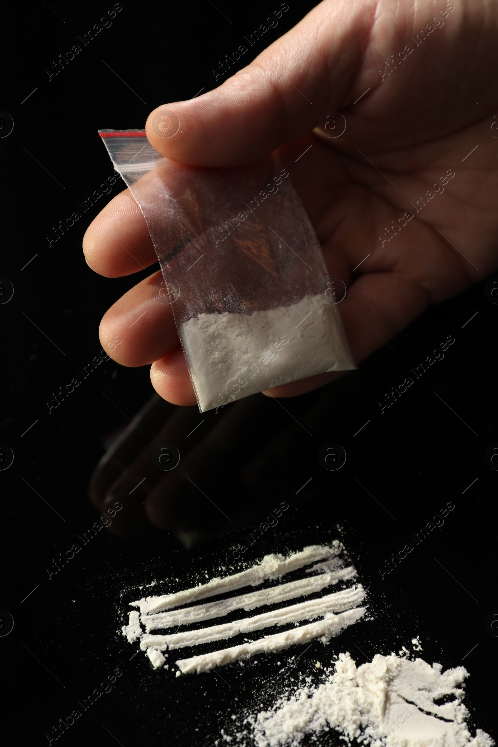 Photo of Drug addiction. Man with cocaine at black table, closeup