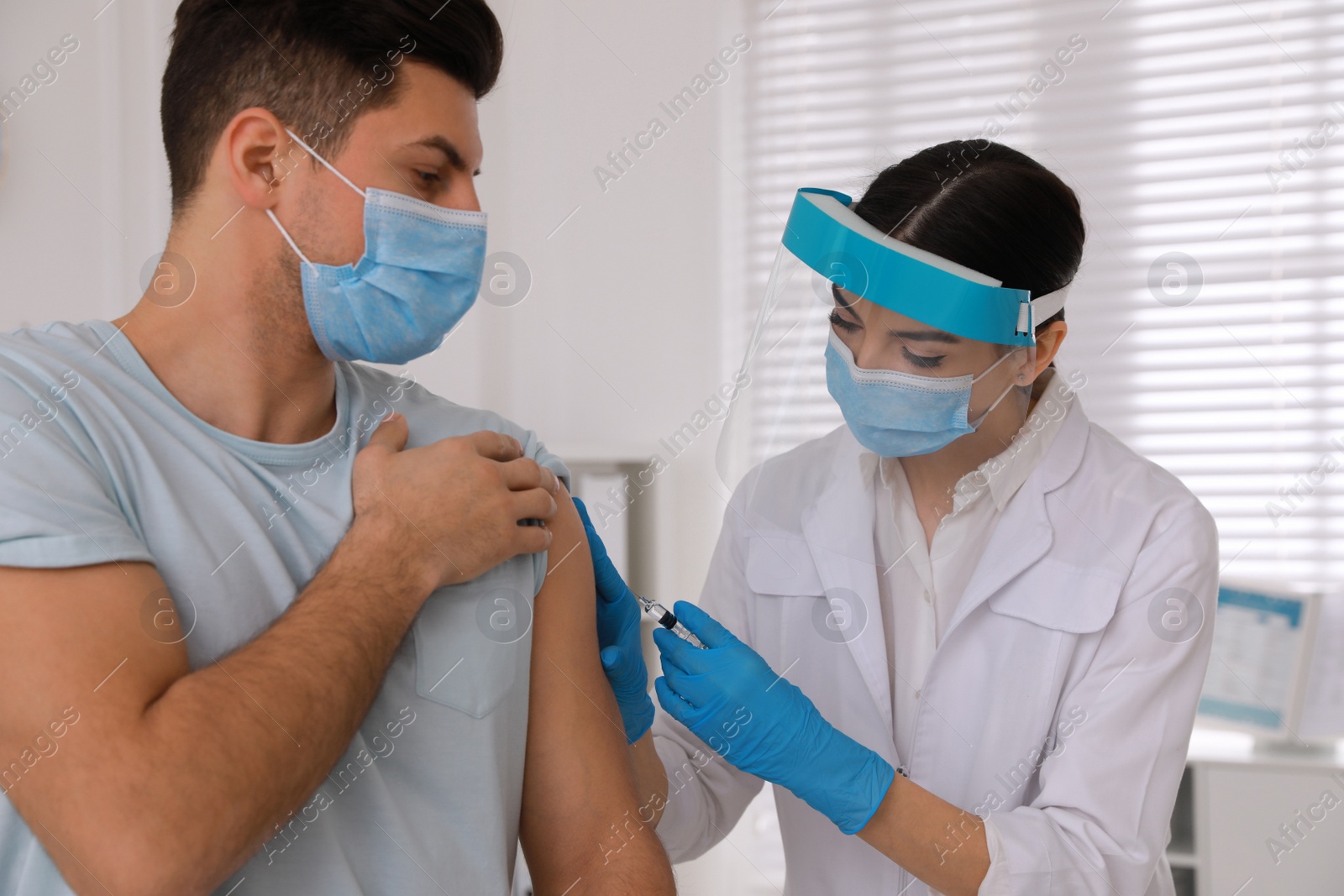 Photo of Doctor giving injection to patient in hospital. Vaccination campaign