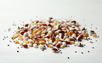 Mixed vegetable seeds on white wooden background