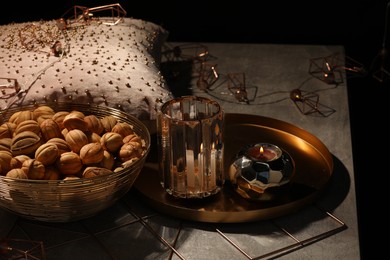 Photo of Delicious walnut shaped cookies, decor and burning candles on grey table. Tasty pastry with filling carrying nostalgic home atmosphere