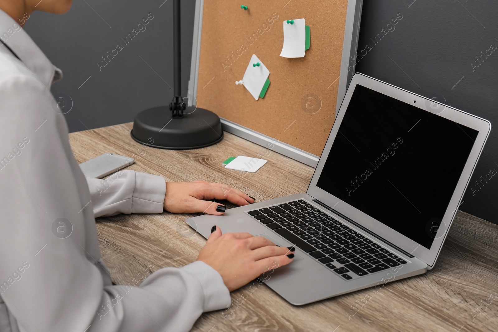 Photo of Woman using laptop at table, closeup. Stylish workplace