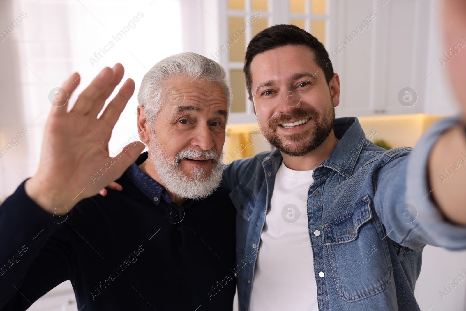 Photo of Happy son and his dad taking selfie at home