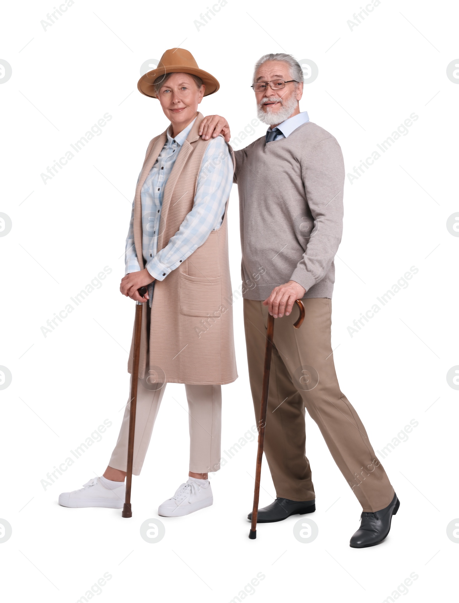 Photo of Senior man and woman with walking canes on white background