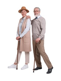 Senior man and woman with walking canes on white background