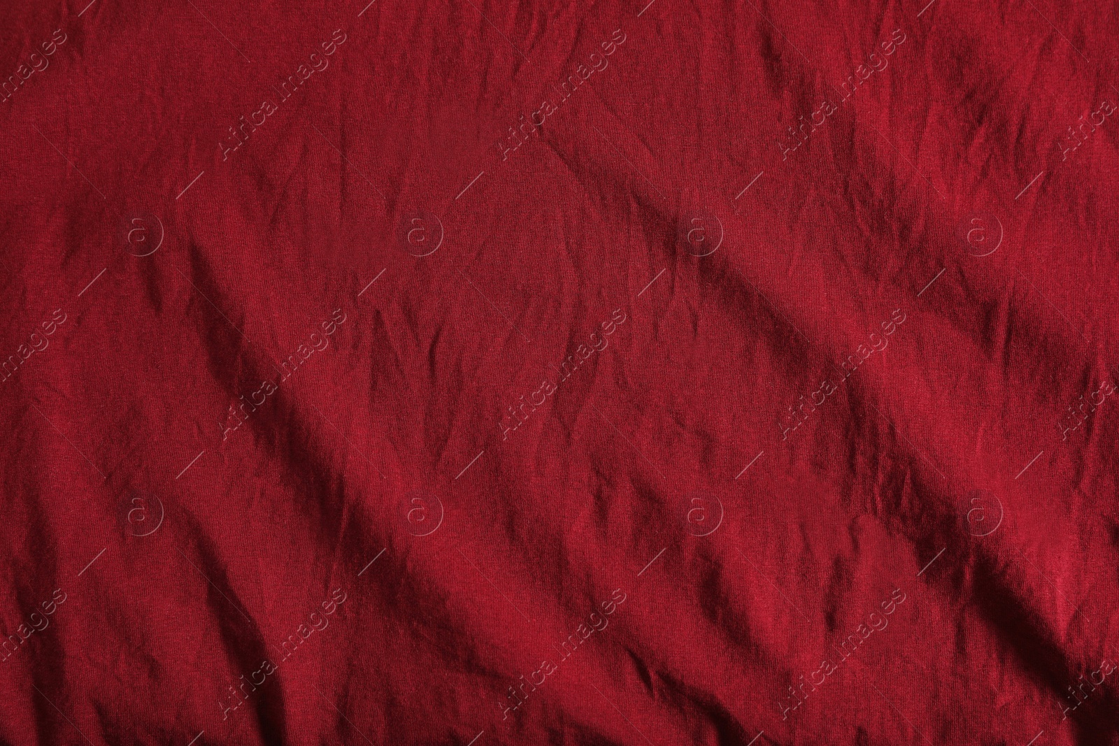 Photo of Crumpled dark red fabric as background, top view