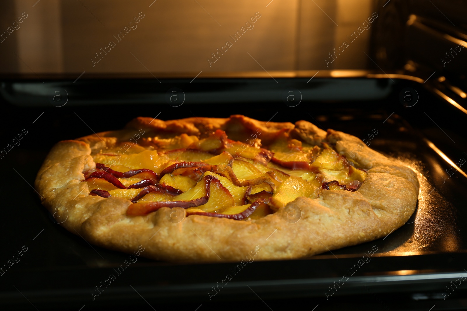 Photo of Baking delicious pie in electric oven, closeup