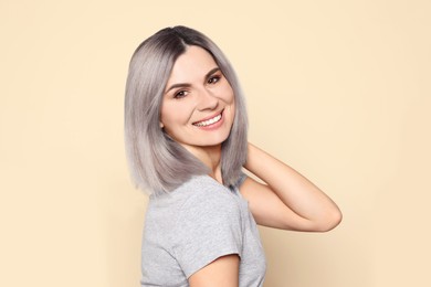 Image of Portrait of smiling woman with ash hair color on beige background