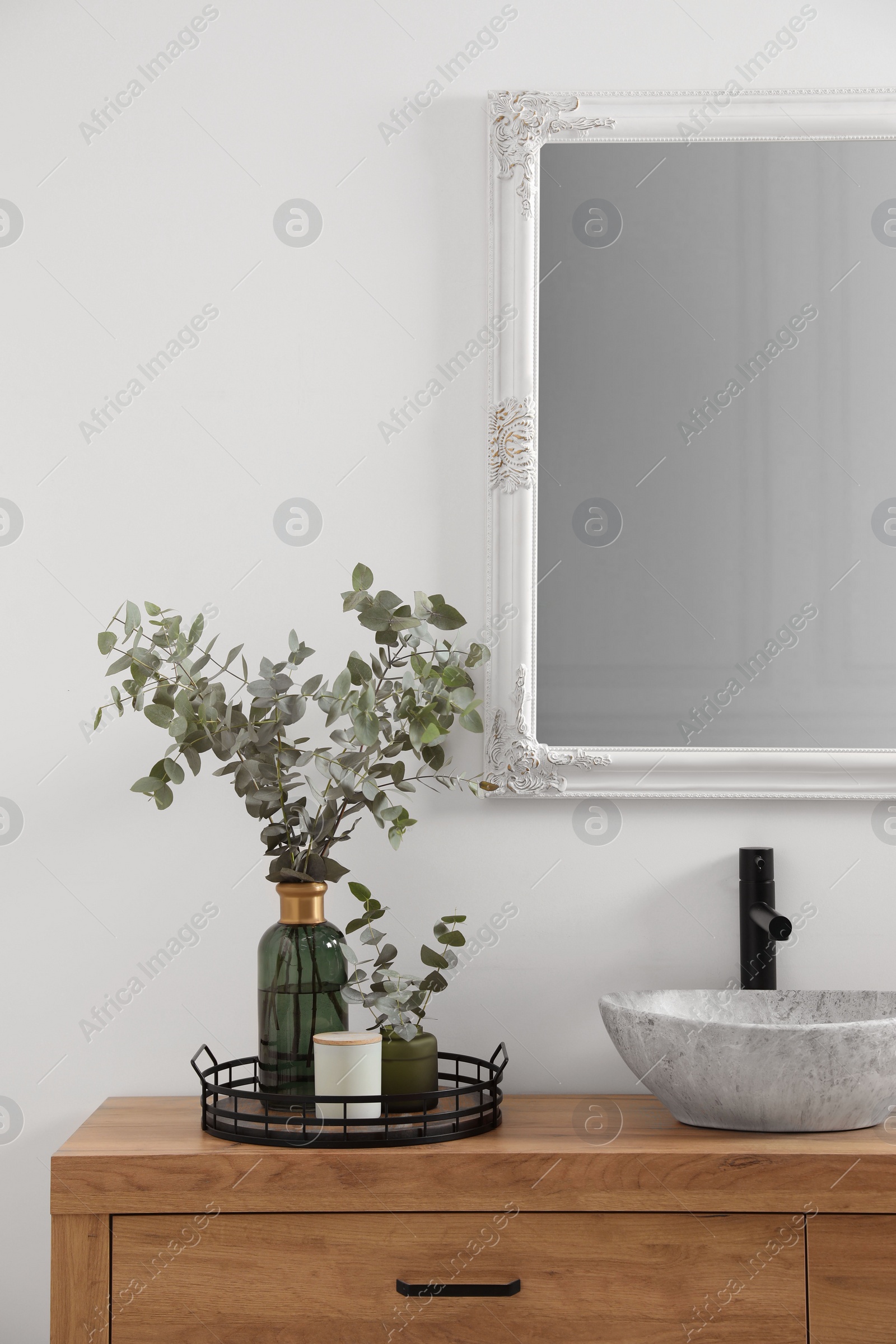 Photo of Beautiful eucalyptus branches near vessel sink on bathroom vanity. Interior design