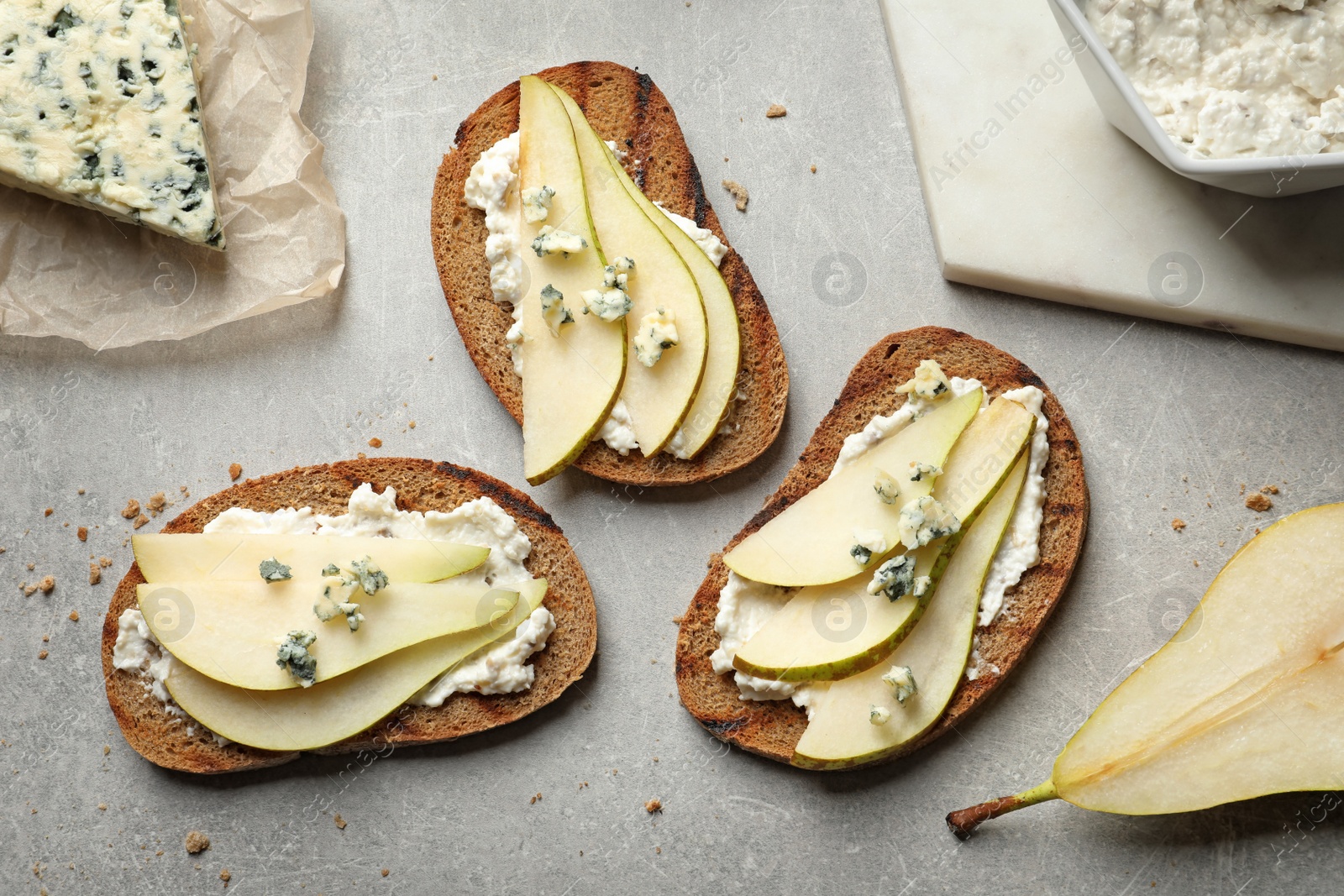 Photo of Delicious bruschettas with pear served on table, flat lay