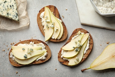 Delicious bruschettas with pear served on table, flat lay