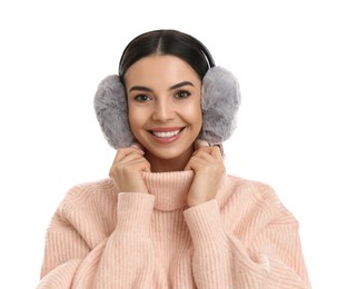 Beautiful young woman wearing earmuffs on white background