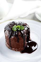 Photo of Delicious warm chocolate lava cake on plate, closeup