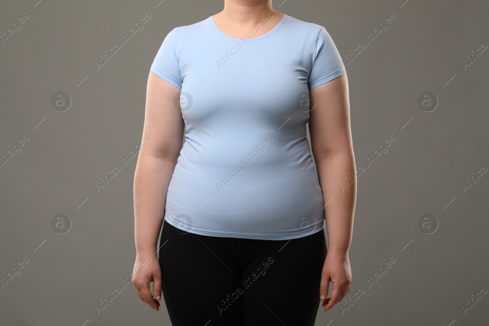 Photo of Overweight woman on grey background, closeup view