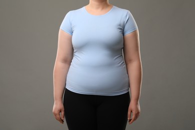 Photo of Overweight woman on grey background, closeup view