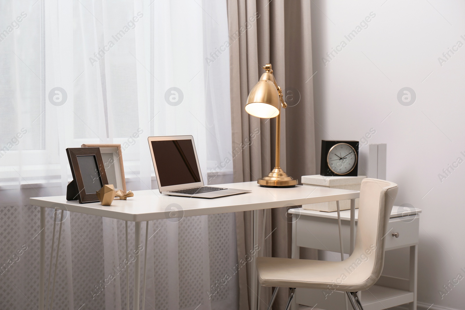 Photo of Stylish workplace with laptop on table in office