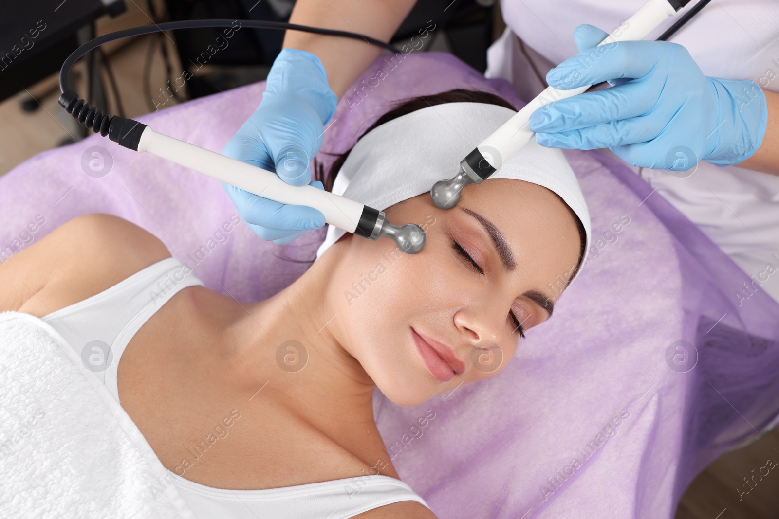 Photo of Young woman undergoing cosmetic procedure in beauty salon. Microcurrent therapy