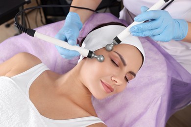 Young woman undergoing cosmetic procedure in beauty salon. Microcurrent therapy