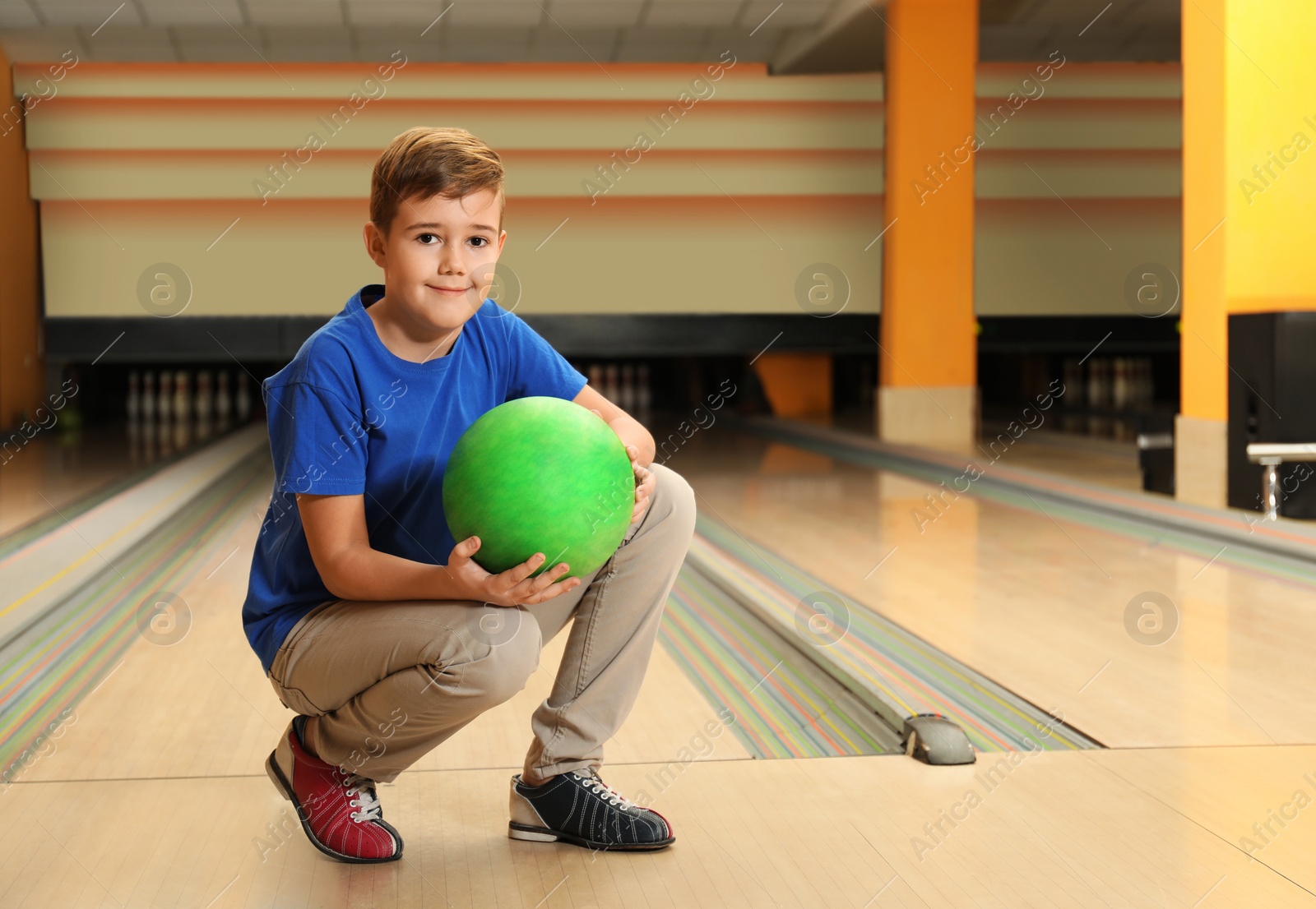 Photo of Preteen boy with ball in bowling club