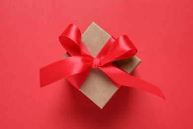 Photo of Beautiful gift box with bow on red background, top view