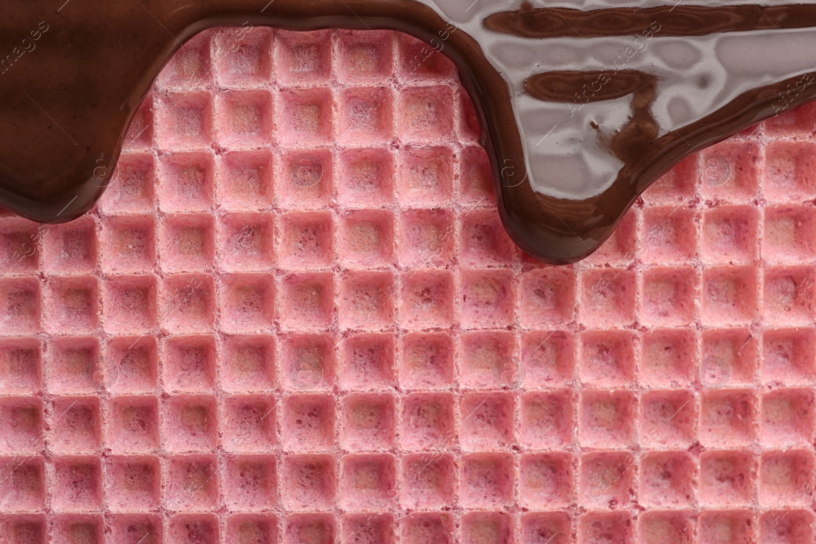 Photo of Hot dark chocolate on wafer, closeup. Crispy food