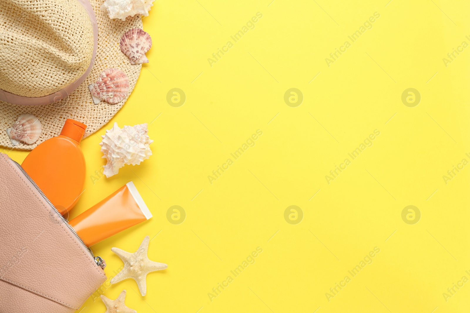 Photo of Sun protection products and beach accessories on yellow background, flat lay. Space for text