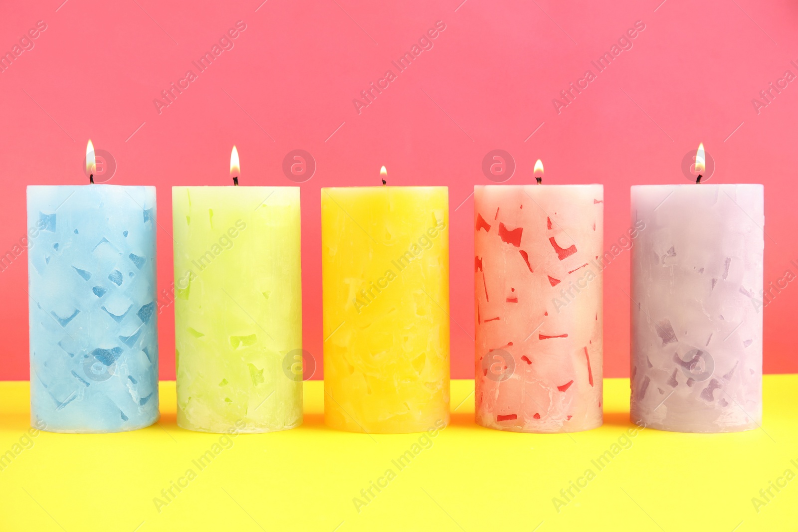 Photo of Alight scented wax candles on color background