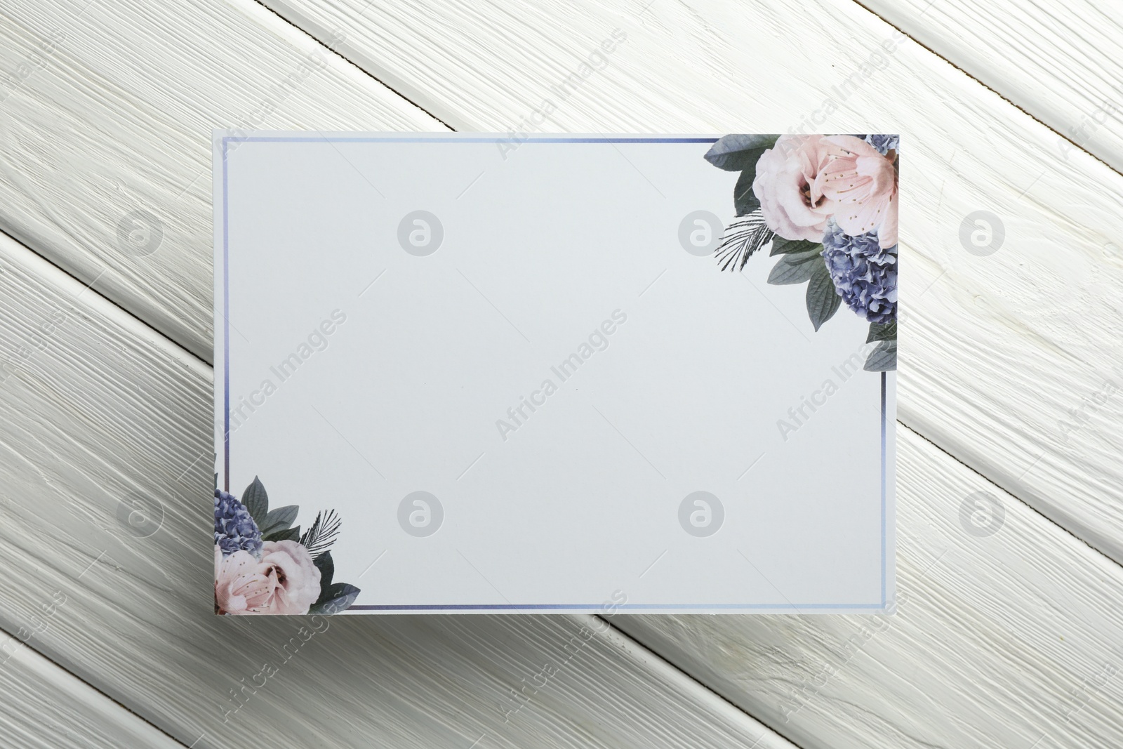 Photo of Blank invitation card on white wooden background, top view. Space for text