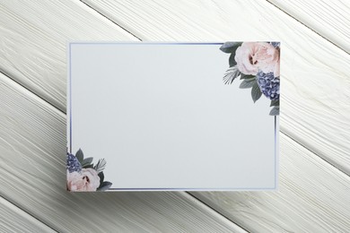 Photo of Blank invitation card on white wooden background, top view. Space for text