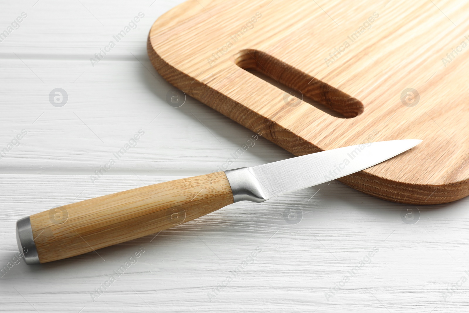 Photo of One sharp knife on white wooden table, closeup