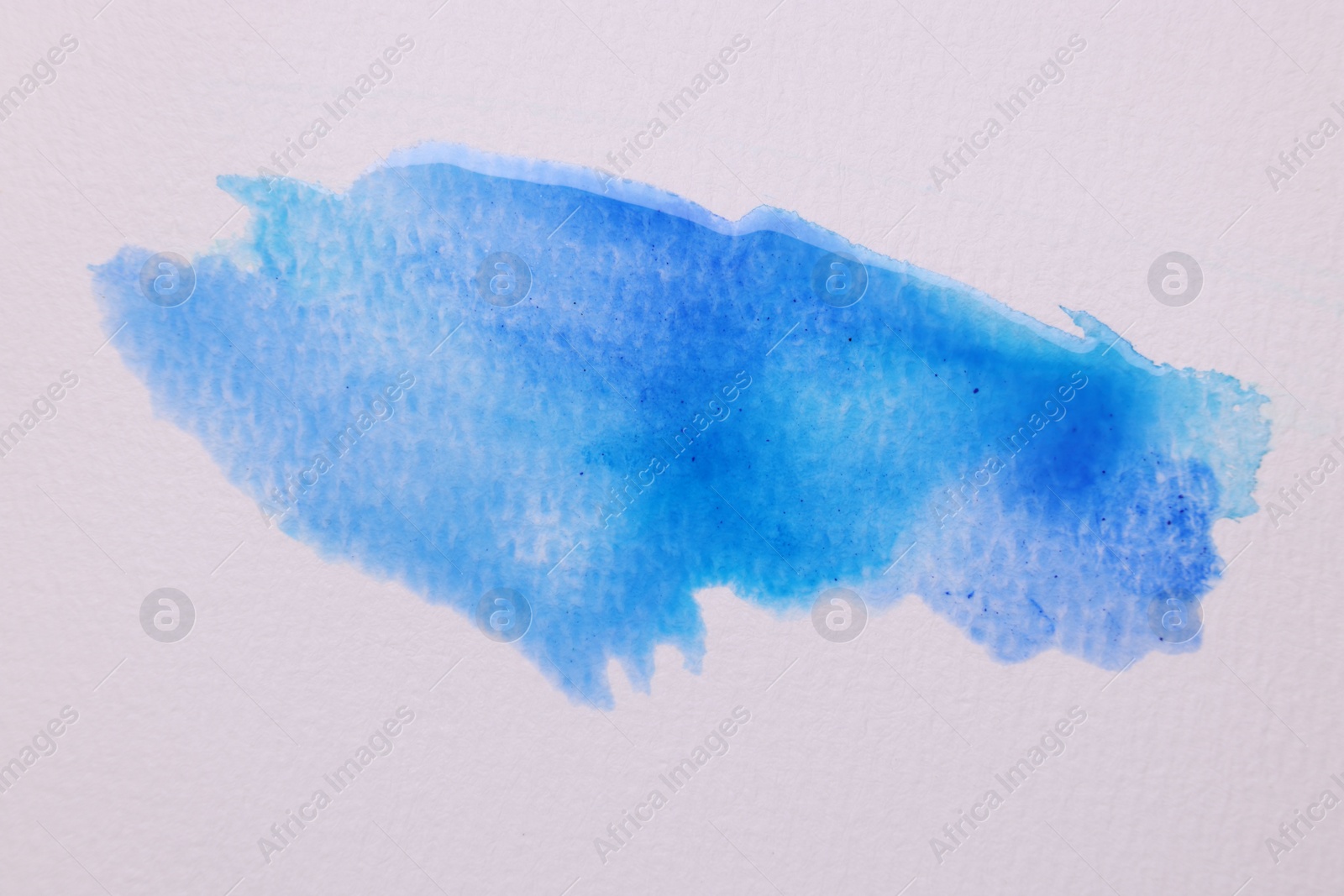 Photo of Blot of blue watercolor paint on white paper, top view