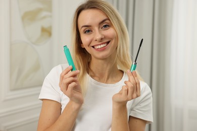 Photo of Beautiful happy woman with mascara at home